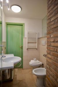 uma casa de banho com uma porta verde e um WC e lavatório em Fororomano Luxury em Roma mais 33 fotografias