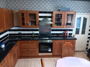 una cucina con mobili in legno e un forno a piano cottura di 2 hampstead Liverpool a Liverpool