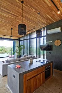 ein Wohnzimmer mit einer Küche und einem Sofa in der Unterkunft SELVA RESORT Ocean View Luxury Villas in Playa Santa Teresa