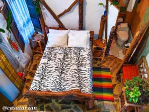 a bedroom with a bed with a zebra print blanket at Hotel Casa Tarzan San Agustin in San Agustín