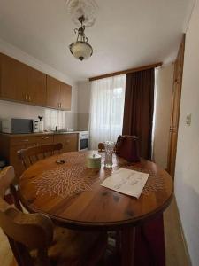 a kitchen with a wooden table with chairs and a dining room at Ilidža Saraj Apartment in Sarajevo