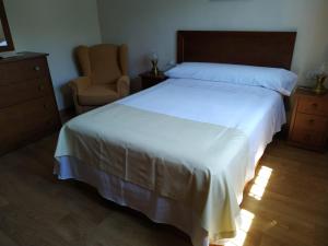 a bedroom with a large white bed and a chair at Villa Sara in Ribadeo