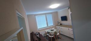 a kitchen with a table and chairs and a window at Apartmán pri hrade in Levice