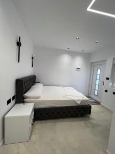 a bedroom with a bed and a white wall at Ländliches Wohnen in Albanien in Petovë