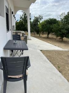 a black table and chair sitting on a porch at Ländliches Wohnen in Albanien in Petovë