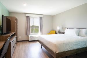 a bedroom with a large bed and a window at ECHO Suites Extended Stay by Wyndham Spartanburg in Spartanburg +28 photos