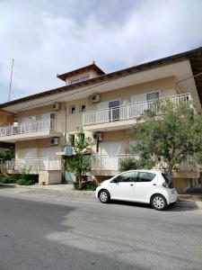 a white car parked in front of a building at Eirini's Hause in Nea Moudania
