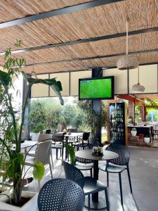 a restaurant with tables and chairs and a flat screen tv at Chalet Ambel in Dhërmi