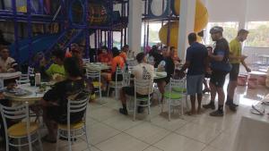 a group of people sitting at tables in a restaurant at Park Hotel in Paraisópolis