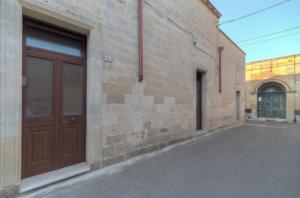 a brick building with a brown door on the side of it at CH Guest Rooms in Vernole