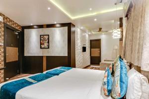 a bedroom with a large white bed and a bathroom at Hotel ACME in Kolkata