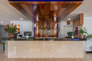 an office lobby with a reception counter with plants at Rodeway Inn Clermont - Minneola - Groveland - Leeseburg in Clermont +13 photos