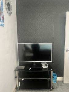 a flat screen tv sitting on top of a black table at Tilbury Home For short letting in Tilbury +3 photos