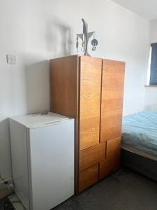 a refrigerator and a cabinet in a room with a bed at Tilbury Home For short letting in Tilbury