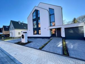 a large white house with a driveway at Luxuswohnung 95qm in Waldrandlage zwischen Köln und Düsseldorf-Nähe Messe - Lanxessarena - Bayarena in Leverkusen