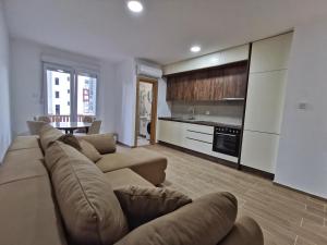 a large living room with a couch and a kitchen at Obala Lux Apartman in Sutomore