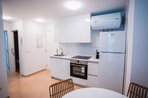 a kitchen with a refrigerator and a table and chairs at Ondas do Mar Boutique Stays - Portonovo 3 in Portonovo