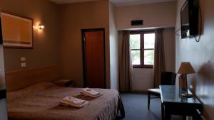 a hotel room with a bed and a desk and a window at Lazaro hotel in Villa Mercedes