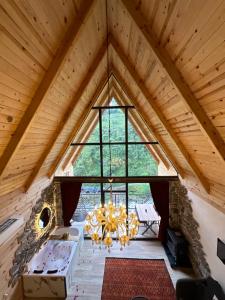 an attic room with a large window and a chandelier at Walnut Bungalow in Çamlıhemşin