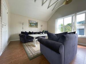 a living room with couches and a table and windows at Hytte Nr 2 in Selje