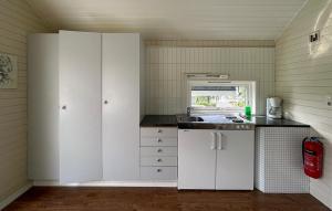 a kitchen with white cabinets and a sink at Hytte Nr 2 in Selje