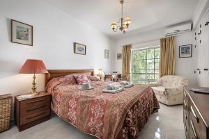 a bedroom with a bed and a chair and a window at Vista Tavira Apartmento in Tavira