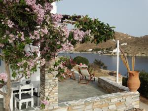 a patio with a table and chairs and pink flowers at Gaia house, Ios Greece in Tzamaria