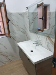 a bathroom with a white sink and a mirror at Centre Vlore Guest House in Vlorë