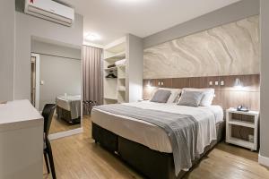 Un dormitorio con una cama grande y un baño. en Valerim Florianópolis, en Florianópolis