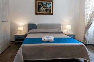 a bedroom with a bed with two lamps and towels on it at Villa Ramona in Noicattaro