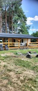 a house with a porch and chairs in front of it at Uroczy domek letniskowy w otoczeniu przyrody in Błonie