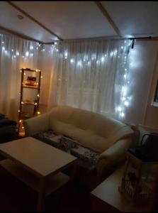 a living room with a couch and a window with lights at Uroczy domek letniskowy w otoczeniu przyrody in Błonie