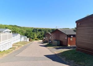 a row of houses on a road next to a fence at Shear Barn Holiday Park in Hastings