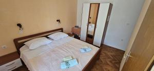 a bedroom with a bed with two towels on it at APARTMANI SANDRA PRPIĆ in Rab