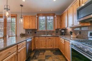 a kitchen with wooden cabinets and stainless steel appliances at Fairway Drive 13113 by East West Hospitality in Truckee +18 photos