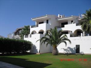a white building with a palm tree in front of it at Son Parc - Albatros in Son Parc