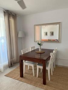 a dining room table with white chairs and a mirror at Son Parc - Albatros in Son Parc