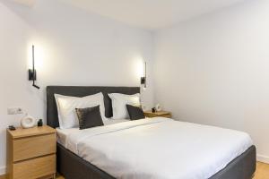 ein Schlafzimmer mit einem großen Bett mit weißer Bettwäsche in der Unterkunft KOA - Davino Aparthotel in Braşov