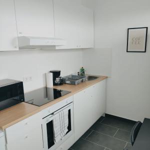 una cucina bianca con un lavello e un forno a microonde di Monteurwohnung Ferienwohnung Business Appartement links Langenfeld a Gladbach
