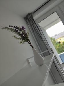 un vaso bianco con dei fiori accanto a una finestra di Monteurwohnung Ferienwohnung Business Appartement links Langenfeld a Gladbach Altre 7 foto
