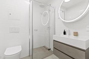 une salle de bain blanche avec lavabo et douche dans l'établissement Modern Apartment I Parking I Vienna, à Vienne 201 autres photos