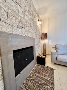 a living room with a large fireplace and a couch at VL Luxury Villa in Kiveri