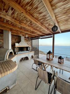 a patio with a fireplace and a table and chairs at VL Luxury Villa in Kiveri