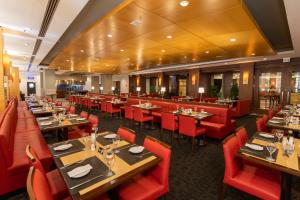 a restaurant with wooden tables and red chairs at Hotel Nacional Inn Jaragua Sao Paulo in Sao Paulo
