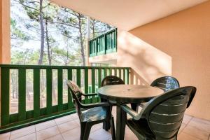 a table and chairs sitting on a balcony at Résidence Les Grands Pins - maeva Home - Appartement 2 pièces 5 personnes - Confort MAE-0384 in Maubuisson