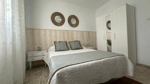 ein Schlafzimmer mit einem Bett und zwei Spiegeln an der Wand in der Unterkunft Susurros del Mar in Conil de la Frontera