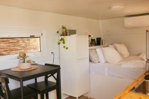 a small kitchen with a table and a bed in a room at קרוואן משקיף לים in HaBonim