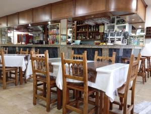 ein Restaurant mit Tischen, Stühlen und einer Bar in der Unterkunft Hostal León II in Porto do Son