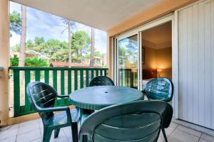 a table and chairs on a balcony with a window at Résidence Les Grands Pins - maeva Home - Appartement 2 pièces 5 personnes - Sélection MAE-2171 in Maubuisson