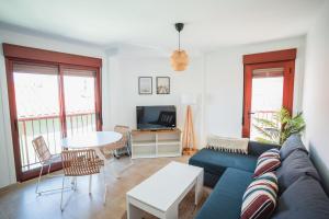 a living room with a blue couch and a table at Ondas do Mar Boutique Stays - Portonovo 4 in Portonovo